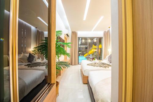 a bedroom with two beds and a potted plant at Anya pool villa pattaya in Ban Huai Yai