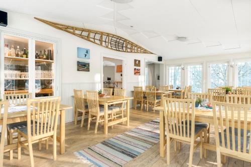 jadalnia z drewnianymi stołami i krzesłami w obiekcie Villa Bro w mieście Brastad