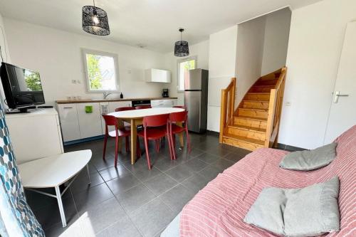 a room with a bed and a table and a kitchen at Maisonnette tout confort - Golf - Piscine in Quéven