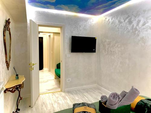 a living room with a tv on a white wall at Golden Station Ultraconfort in Iaşi