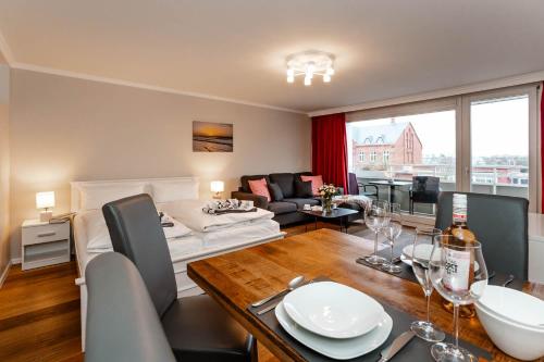 a living room with a table and a dining room at Apartment Di Wiis in Westerland (Sylt)