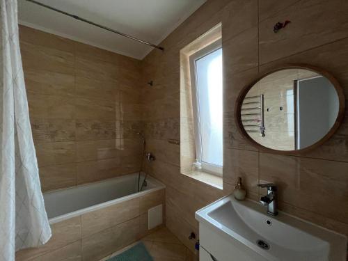 a bathroom with a tub and a sink and a mirror at Апартаменти студія in Truskavets