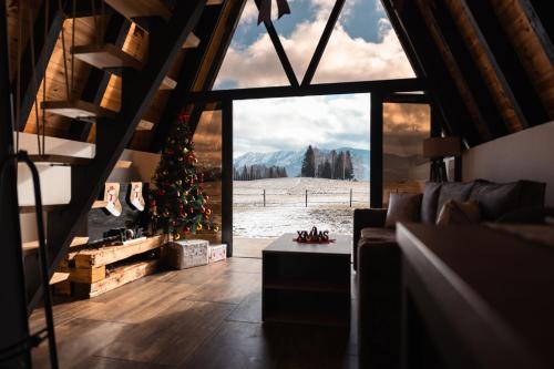 a living room with a christmas tree and a large window at Golden Valley Brezna in Pluzine