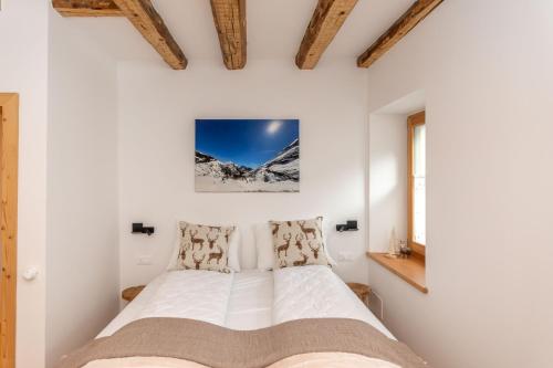 a bedroom with a bed in a white wall at Ciesa dela Maestra in Rocca Pietore