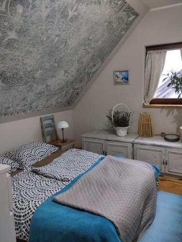 a bedroom with a bed and a window at Klimatyczny dom z bali in Powidz