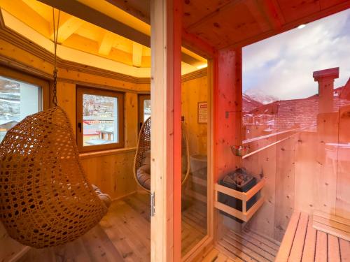 a room with a hammock on the porch of a house at Hotel San Lorenzo in Bormio