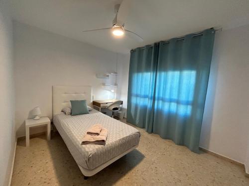 1 dormitorio con 1 cama con cortina azul en VUT Parque II TORREON 4 dormitorios y 2 baños Parking gratuito cercano, en Ciudad Real
