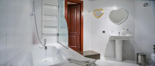 a white bathroom with a tub and a sink at La Gioconda Boutique Hotel in Odesa