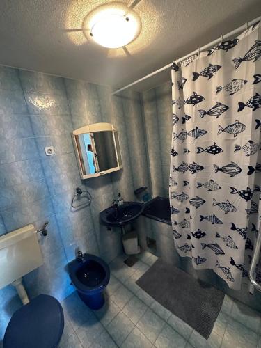 a bathroom with two sinks and a shower curtain with fish on it at Kameni cvijet in Murvica