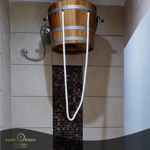a shower with a wooden bucket hanging from the ceiling at Euro Park Otel in Istanbul