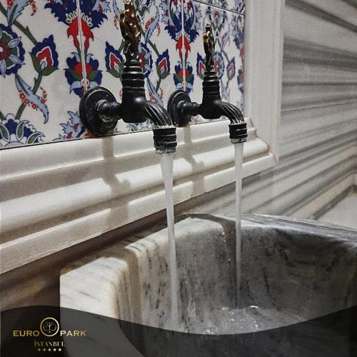 two water faucets are pouring into a sink at Euro Park Otel in Istanbul