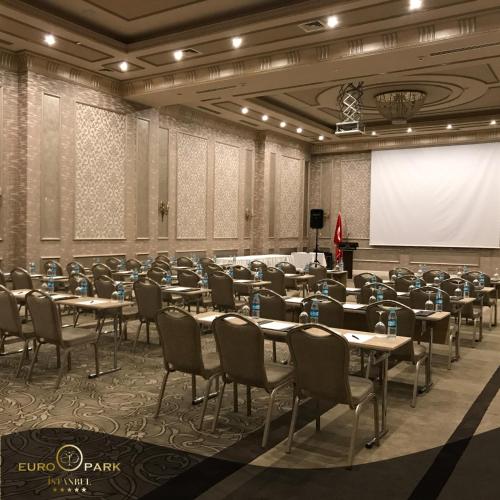 a conference room with tables and chairs and a screen at Euro Park Otel in Istanbul