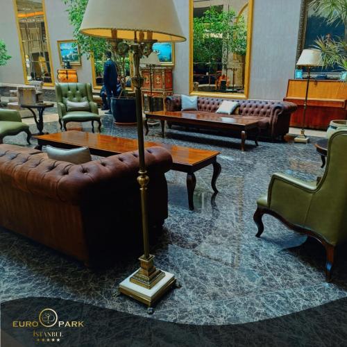 a living room with couches and a table and a lamp at Euro Park Otel in Istanbul