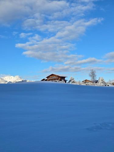 a house on top of a snow covered field at Bergblick Lodge - 3 Sterne Garni - Neueröffnung in Aeschi