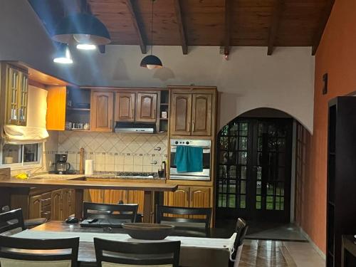 a kitchen with wooden cabinets and a table and chairs at QUINTA LA ARAUCARIA -Paraná in Paraná