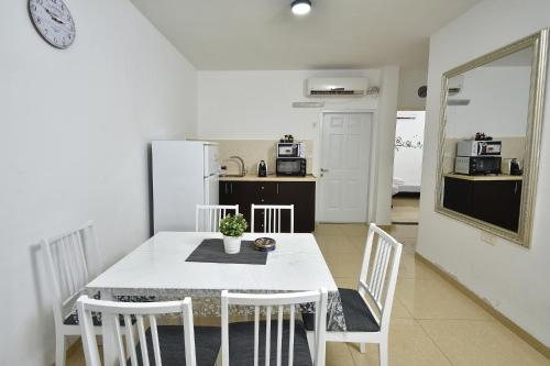 a kitchen and dining room with a white table and chairs at אחוזת איריס הגליל - וילה וסוויטות מושלמות עם בריכה מחוממת in Migdal
