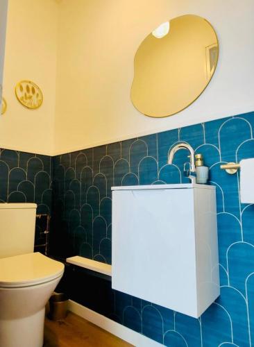 une salle de bain avec toilettes, lavabo et miroir dans l'établissement Petite maison centre-ville, à Nemours