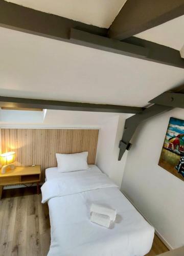 - une chambre avec 2 lits blancs dans l'établissement Petite maison centre-ville, à Nemours