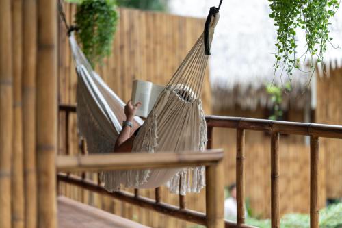 a person laying in a hammock with a book at Coconut Bay Eco Resort in Srithanu