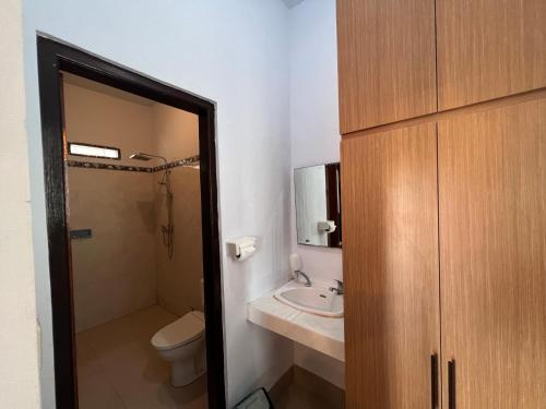 a bathroom with a toilet and a sink at Sela Cottages in Toyapakeh