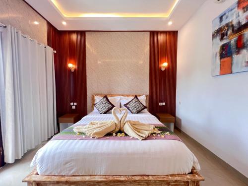 a bedroom with a large bed with towels on it at Sela Cottages in Toyapakeh