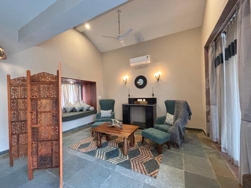 a living room with a table and chairs and a fireplace at Neem Sarai Sariska in Tehla