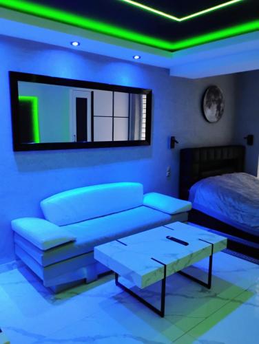 a living room with a bed and a green light at Apartament Miami in Ełk