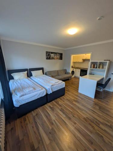a bedroom with a bed and a living room at 1,5-Zimmer Apartment mit Balkon am Hauptbahnhof in Neumünster