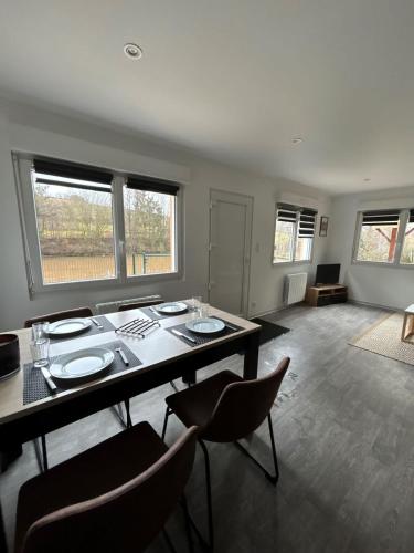 une salle à manger avec une table, des chaises et des fenêtres dans l'établissement Tiny house avec étang privé, à Frahier-et-Châtebier