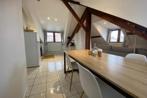 une cuisine et une salle à manger avec une table et des chaises en bois dans l'établissement Le Central-Gare-Centre ville-Idéalement situé, à Montbéliard