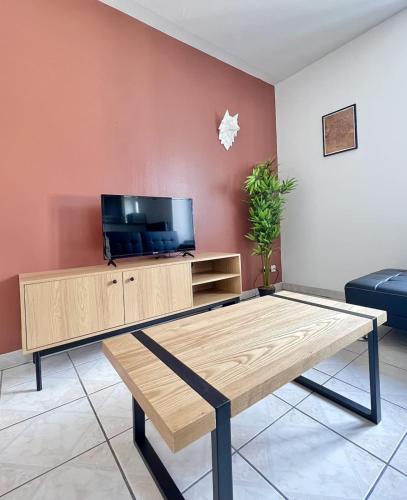 - un salon avec une table basse et une télévision dans l'établissement Le Paisible d'Audincourt, à Audincourt