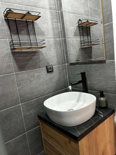 a bathroom with a white sink and a mirror at Apartman Aska - Residence Hill in Kopaonik