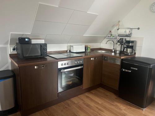eine kleine Küche mit Mikrowelle und Herd in der Unterkunft Ferienwohnungen AugenBlick 2 Naumburg in Naumburg