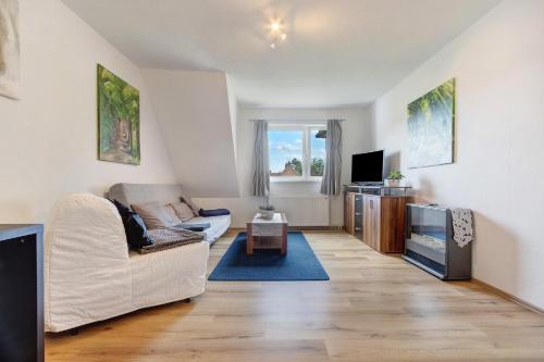 a living room with a white couch and a tv at Rode in Faßberg