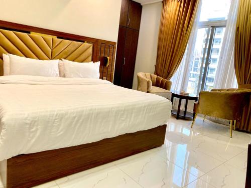 a hotel room with a large bed and a chair at Ambrina Hotel in Islamabad