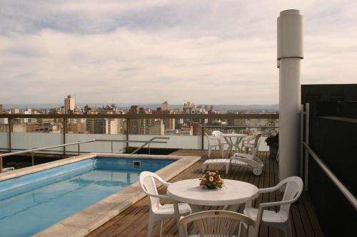 uma varanda com uma piscina, uma mesa e cadeiras em King David Flat Hotel - Argentina em Córdova