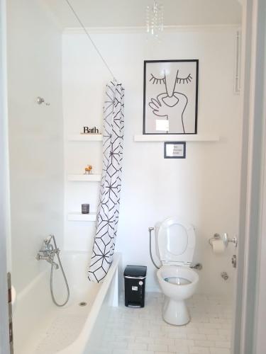 a white bathroom with a toilet and a sink at Σπίτι - Κάστρο πάνω από τη θάλασσα in Piraeus