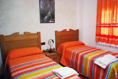 una camera con due letti con coperte colorate di Casa Rural CerroMoreno a Villarta