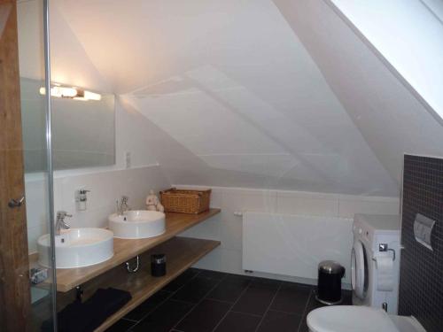 une salle de bain avec deux lavabos et un WC dans l'établissement Ferienwohnung Zur Alten Backstube, à Trebbin