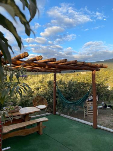 a wooden pergola with a table and a bench at Suíte Capônica -Capão Vibes in Palmeiras