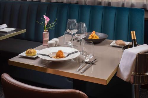 a table with plates of food and wine glasses at NH Firenze in Florence