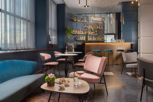 a restaurant with tables and chairs and a bar at NH Firenze in Florence