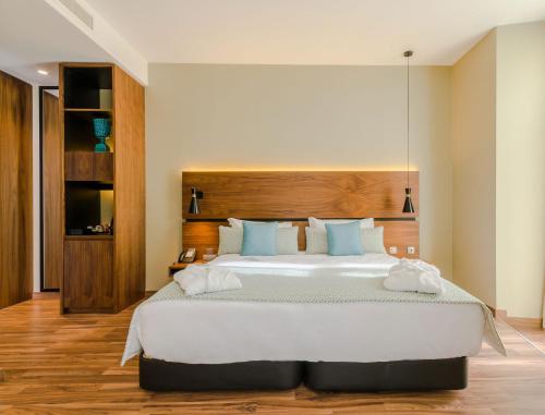 a bedroom with a large bed with a wooden headboard at Vincci Liberdade in Lisbon