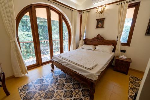 a bedroom with a bed and a large window at Ishaan Holiday Home in Nagaon