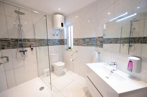a bathroom with a shower and a toilet and a sink at The Exiles Hotel in Sliema