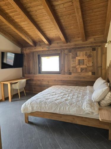a bedroom with a bed in a wooden room at Maison Gal in Nus