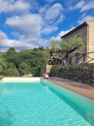 a swimming pool in front of a house with a stone wall at Casolare Cento Ulivi Luxury & Charme - Villa exclusive use in Ascea