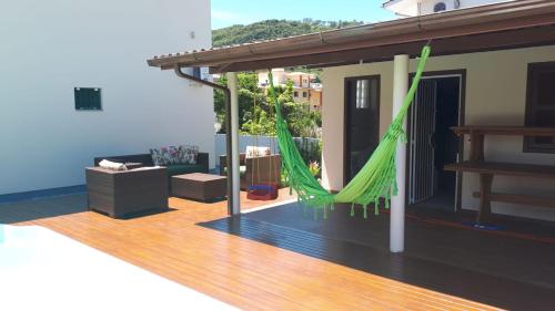 a living room with a hammock on a deck at Residencial do Angelo - Pinheira in Pinheira