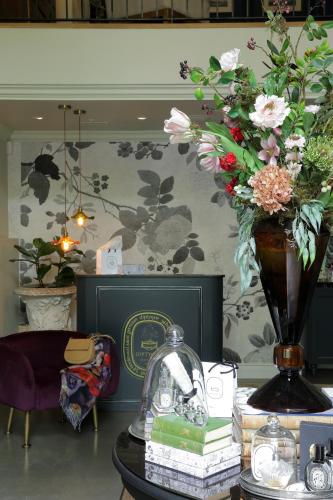 a room with a table with a vase of flowers at Labotessa Luxury Boutique Hotel in Cape Town