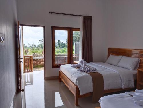 a bedroom with two beds and a balcony at Nan Bungalows Tetebatu in Tetebatu